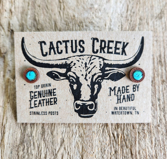 Cactus Creek leather earring card with bull illustration on a wooden surface