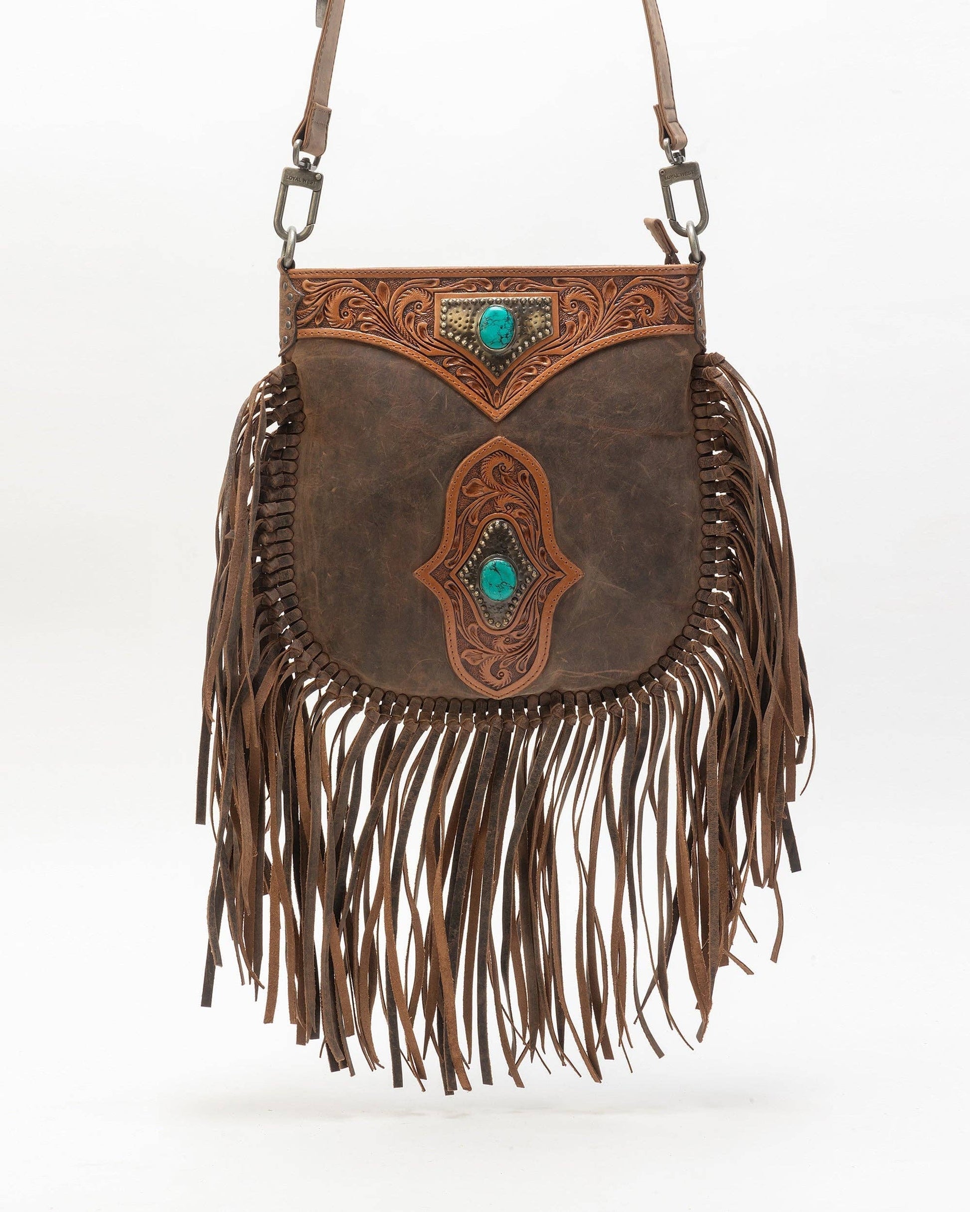 Brown leather handbag with fringe and intricate designs on a white background