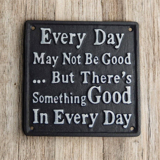 Decorative metal sign with motivational quote on a wooden background