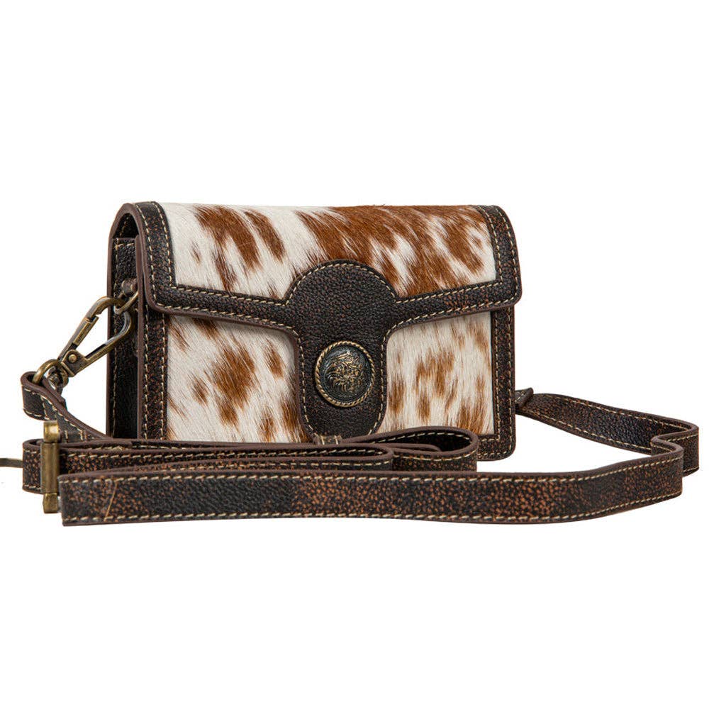 Brown and white cowhide leather crossbody bag on a white background