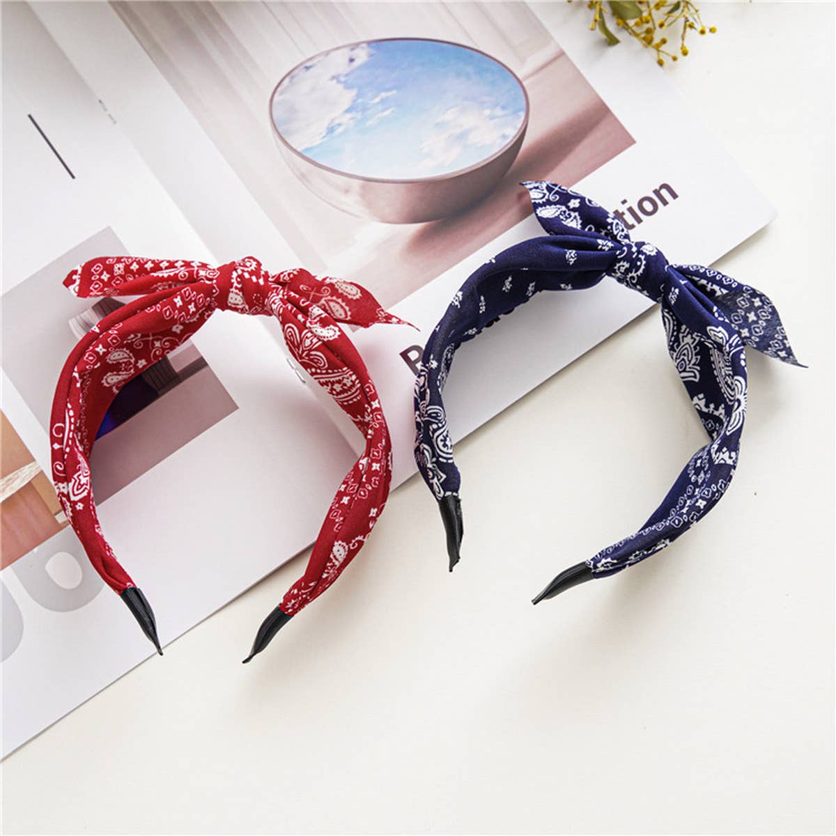 Two headbands, one red and one blue, on a magazine with a blurred background.