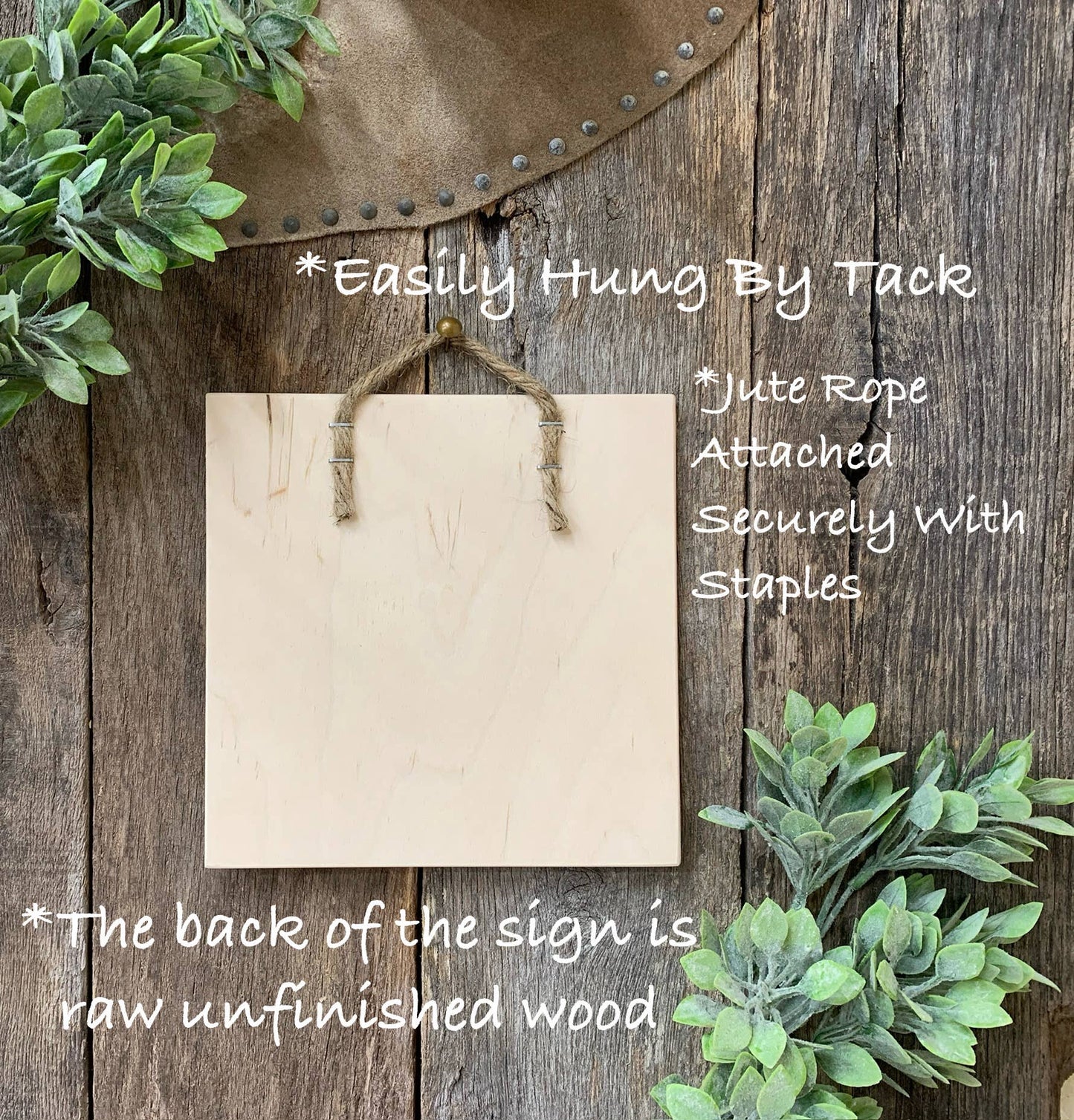 Blank wooden sign with jute rope and greenery on a rustic wooden background
