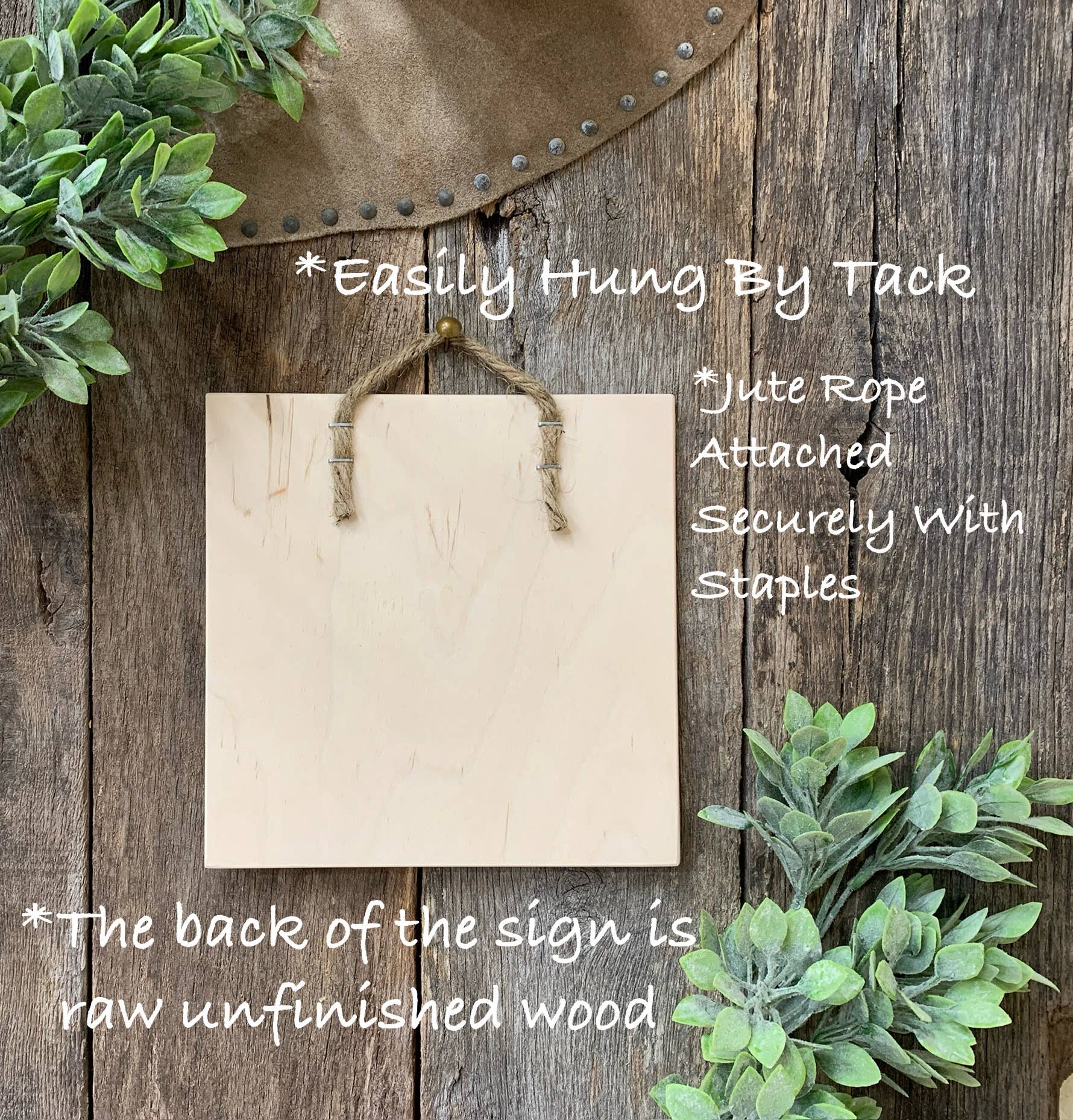 Blank wooden sign with jute rope and greenery on a rustic wooden background