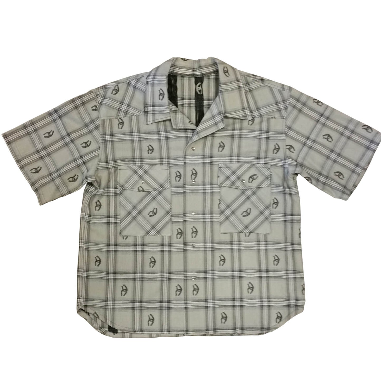 Stay stylish and cool in this short sleeve cotton shirt. Woven designs of horseshoes scatter the plaid pattern adding western flair. Two front pockets and pearl snap closures. Great for parties or concerts or any summer event that you need to look your best. Made in USA 