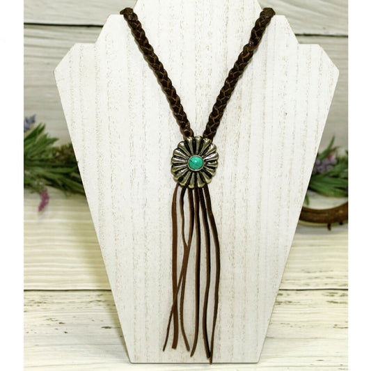 Very cute, very versatile, very trendy leather and concho necklace. Add this to your collection and it will be your go to piece! Braided leather laces with a concho accent and long fringe detail. Measures 20" long end to end.