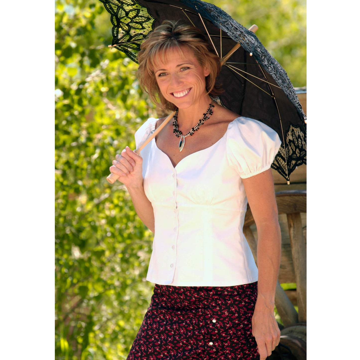 Soft and feminine, this blouse has a sweetheart neckline and an empire seam with delicate buttons down the front. The sleeves can be altered to your mood with its’ elastic fit. Wear them off the shoulders for that fun, flirty mood or up on top for a more conservative look. Self-lined. 100% fine cotton. Made in USA